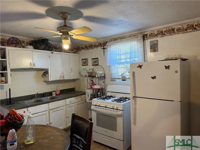 kitchen featuring white appliances, white cabinets, crown molding, sink, and ceiling fan