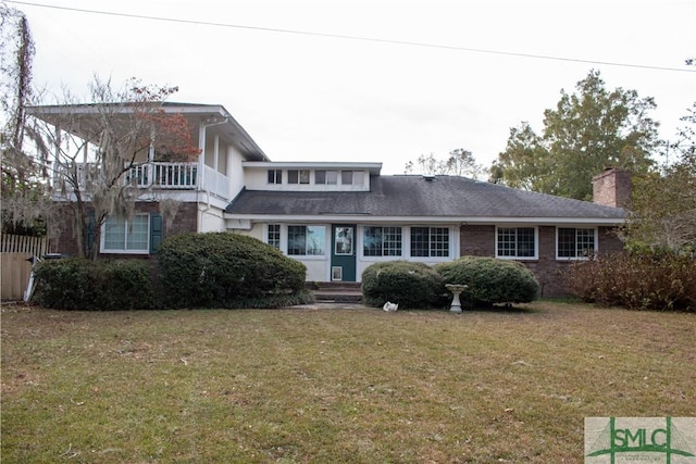 view of front facade featuring a balcony and a front lawn