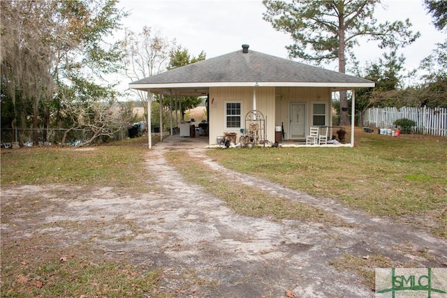 back of house featuring a carport and a yard