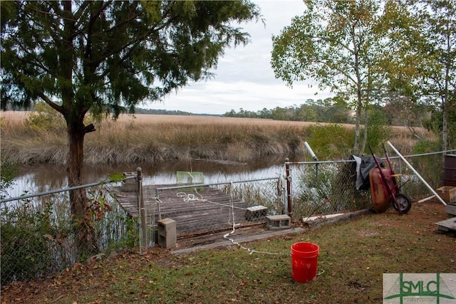 view of dock with a rural view and a water view