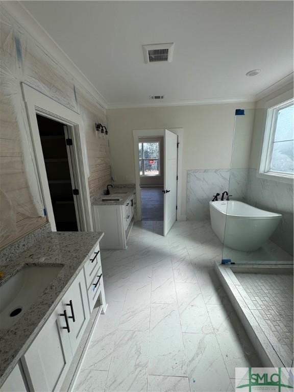 bathroom with crown molding, vanity, a bath, and tile walls