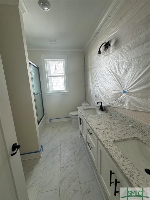 full bathroom featuring bath / shower combo with glass door, ornamental molding, toilet, and vanity