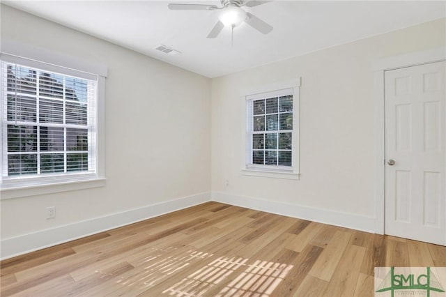 empty room featuring ceiling fan, plenty of natural light, and light wood-type flooring