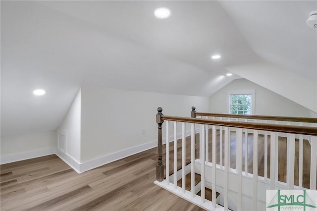 hall with hardwood / wood-style flooring and lofted ceiling