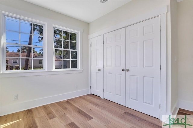 unfurnished bedroom featuring light hardwood / wood-style flooring and a closet