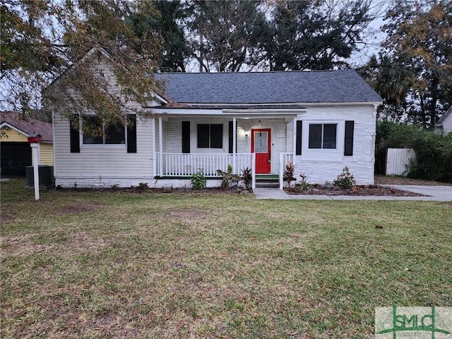 view of front of home with central AC unit, a porch, and a front lawn