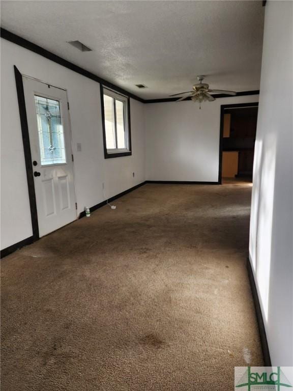 carpeted entrance foyer featuring ceiling fan, crown molding, and a textured ceiling