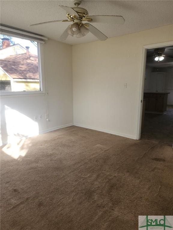 carpeted empty room featuring ceiling fan and a textured ceiling