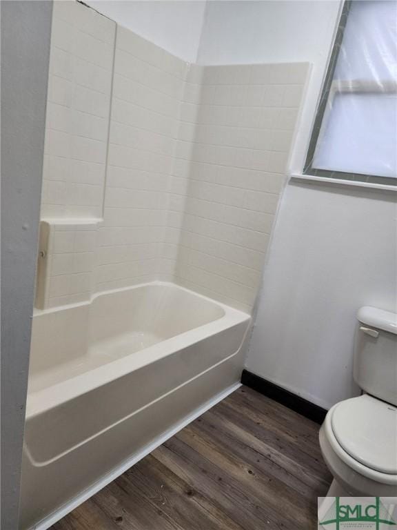 bathroom with hardwood / wood-style flooring, toilet, and tub / shower combination