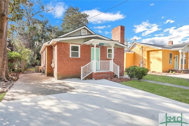 bungalow-style house featuring a front lawn and cooling unit