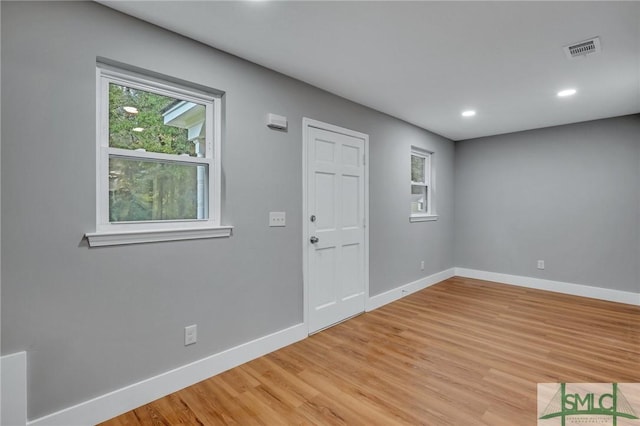 foyer entrance with a wealth of natural light and light hardwood / wood-style flooring