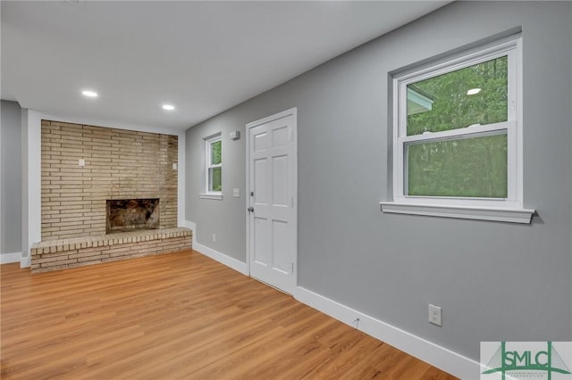 unfurnished living room with a fireplace and light hardwood / wood-style flooring