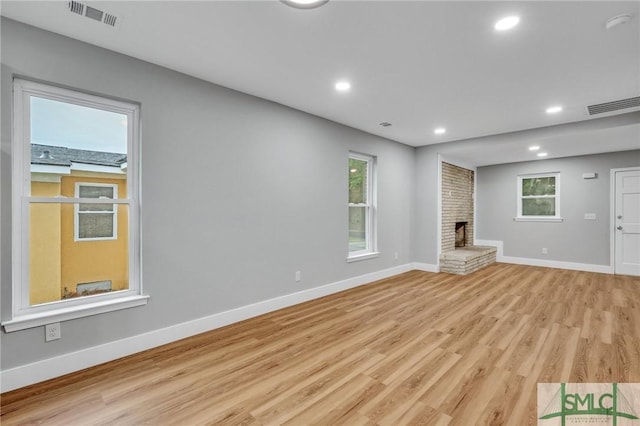 unfurnished living room with a fireplace and light hardwood / wood-style floors