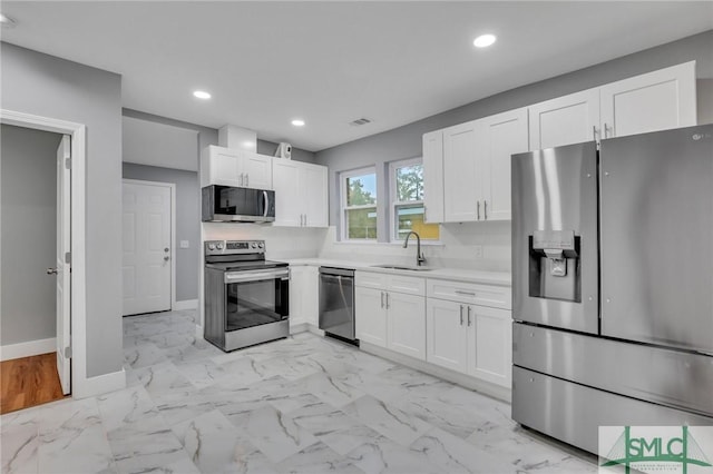 kitchen featuring stainless steel appliances, white cabinetry, and sink