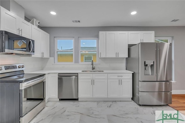 kitchen featuring appliances with stainless steel finishes, white cabinetry, and sink