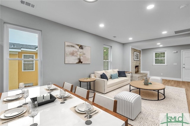 living room with a fireplace and light wood-type flooring