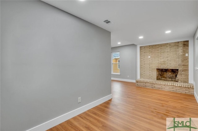 unfurnished living room with a fireplace and light hardwood / wood-style flooring