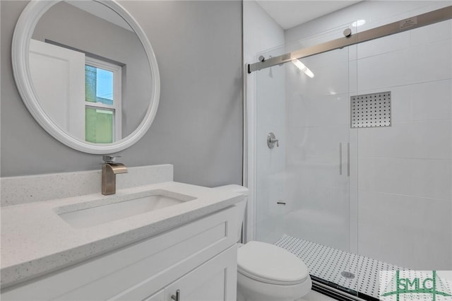 bathroom featuring vanity, toilet, and a shower with shower door