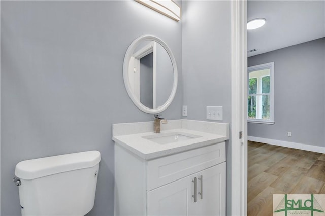 bathroom with vanity, wood-type flooring, and toilet