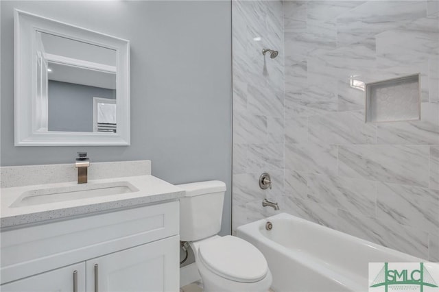 full bathroom featuring vanity, tiled shower / bath combo, and toilet