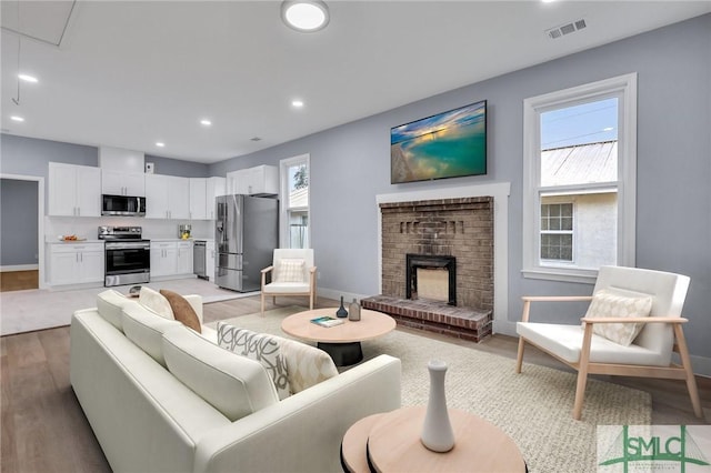 living room with a fireplace and light hardwood / wood-style floors