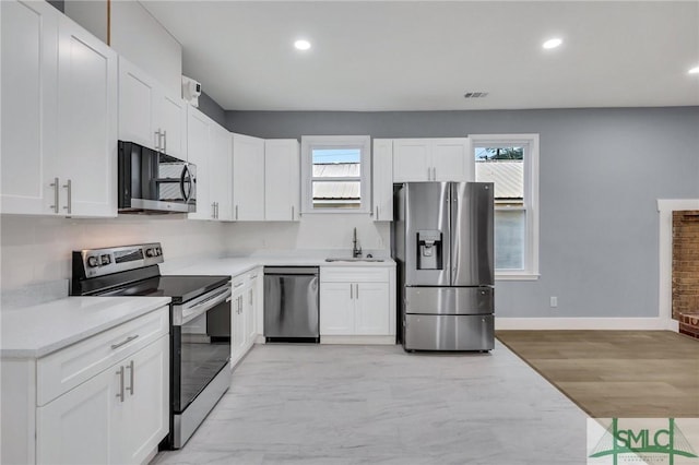 kitchen featuring white cabinets, stainless steel appliances, light hardwood / wood-style floors, and sink