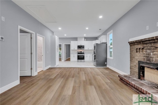 unfurnished living room with a fireplace and light hardwood / wood-style flooring