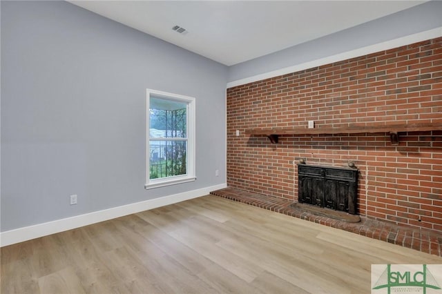 unfurnished living room featuring a fireplace and hardwood / wood-style floors