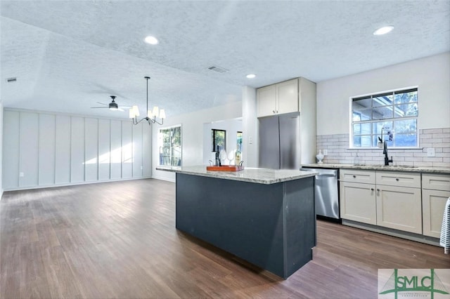 kitchen with dishwasher, a center island, decorative light fixtures, and dark wood-type flooring