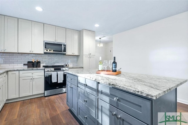 kitchen with stainless steel appliances, gray cabinets, and dark hardwood / wood-style floors