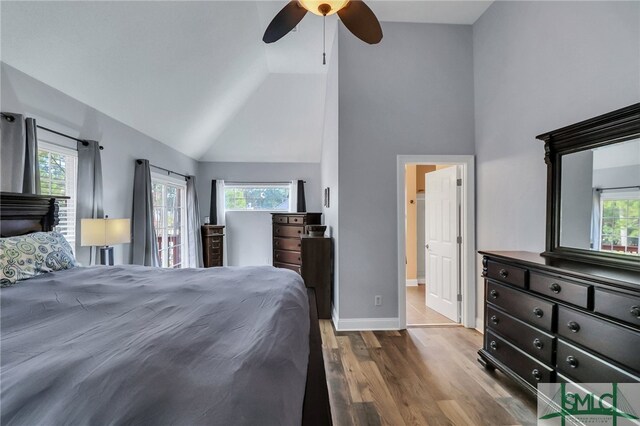 bedroom with hardwood / wood-style floors, ensuite bath, multiple windows, and ceiling fan