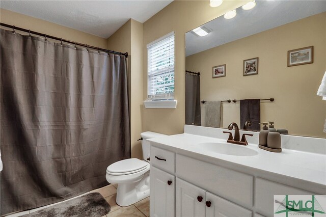 bathroom featuring tile patterned flooring, vanity, and toilet