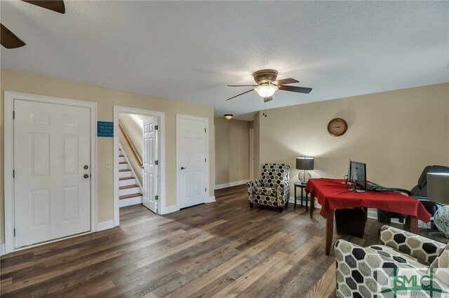 game room featuring a textured ceiling, ceiling fan, and dark wood-type flooring