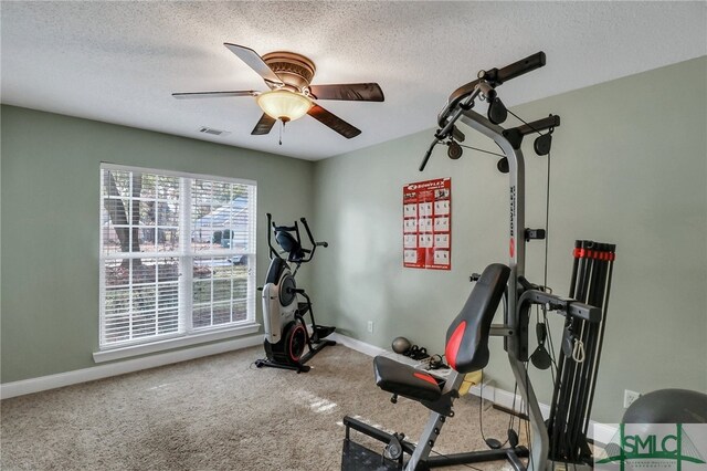 exercise area with carpet flooring, ceiling fan, and a textured ceiling