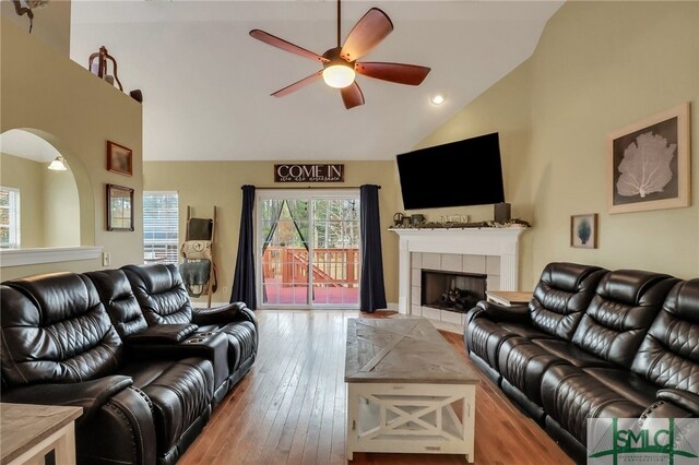 living room featuring a fireplace, high vaulted ceiling, light hardwood / wood-style flooring, and ceiling fan