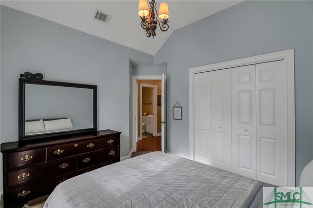 bedroom featuring a notable chandelier, lofted ceiling, and a closet