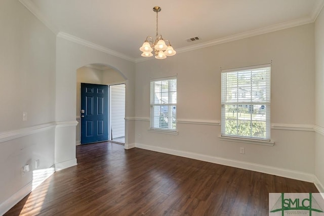 spare room with crown molding, dark wood-type flooring, and a notable chandelier