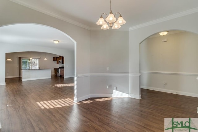 unfurnished room featuring dark hardwood / wood-style flooring, ornamental molding, and an inviting chandelier