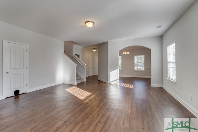 unfurnished room with dark wood-type flooring and an inviting chandelier