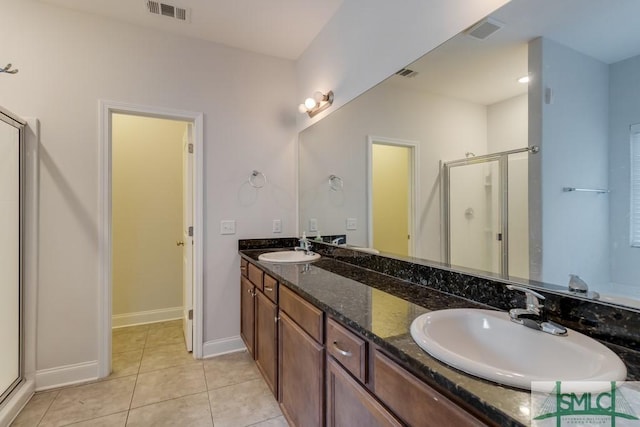 bathroom with tile patterned flooring, vanity, and an enclosed shower