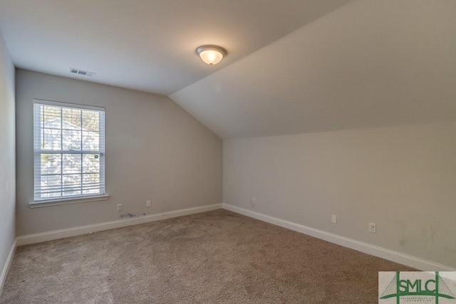 additional living space featuring light colored carpet and lofted ceiling