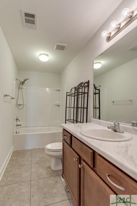 full bathroom with tile patterned floors, vanity,  shower combination, and toilet