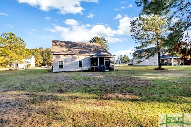 back of house with a lawn and a sunroom