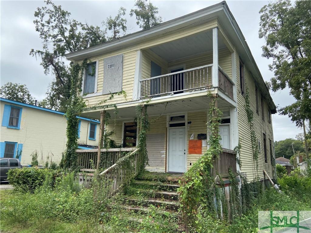 view of front of property with covered porch and a balcony