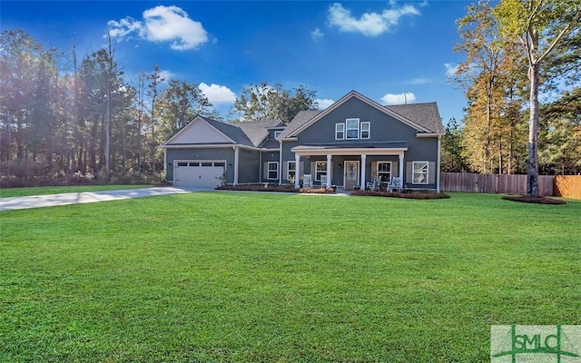 view of front of property with covered porch, a garage, and a front yard