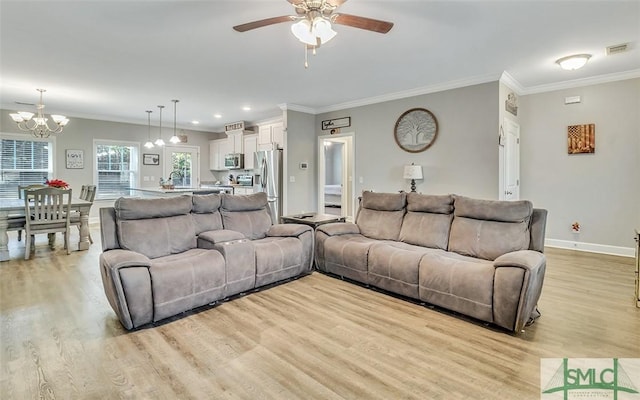 living room featuring ceiling fan with notable chandelier, light hardwood / wood-style flooring, and ornamental molding