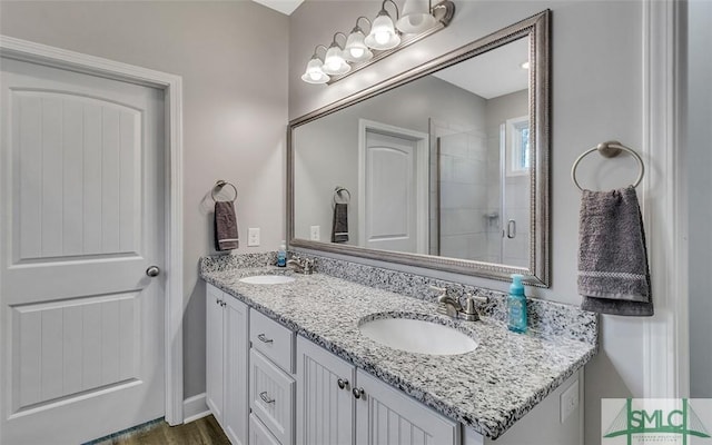 bathroom featuring hardwood / wood-style floors, vanity, and a shower with shower door