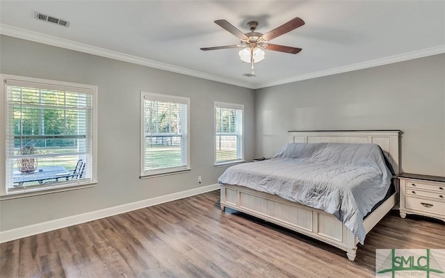 bedroom with ceiling fan, crown molding, and wood-type flooring