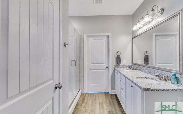 bathroom with vanity, hardwood / wood-style flooring, and a shower with shower door