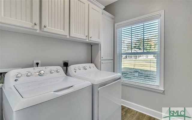 clothes washing area featuring dark hardwood / wood-style flooring, cabinets, and washing machine and dryer